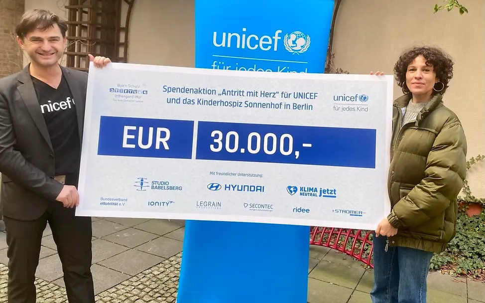 Jasmin Gerat und Lenn Kudrjawizki, | © UNICEF/UN0458297/Berger Lenn Kudrjawizki und Jasmin Gerat mit einem Spendenscheck