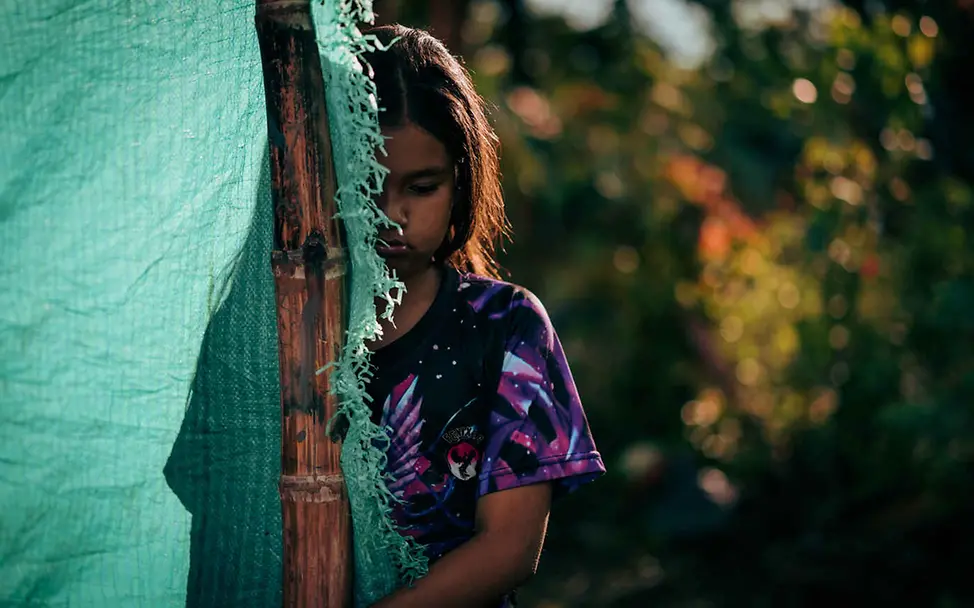 Recht auf gewaltfreie Erziehung: Ein Mädchen steht halb verdeckt hinter einer Plane.