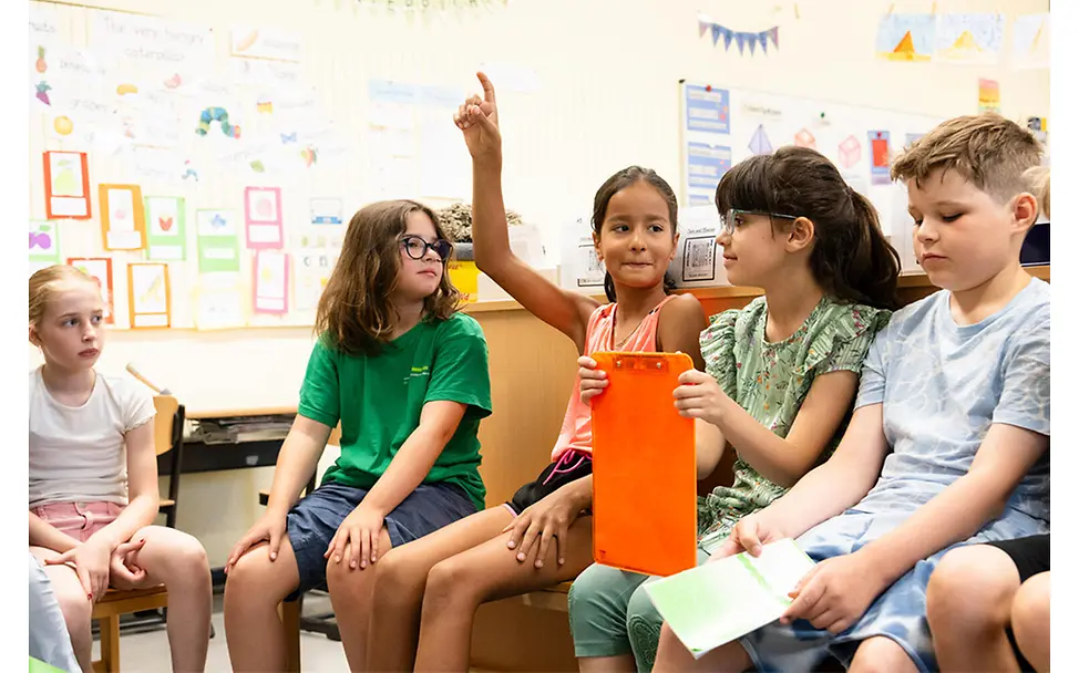Kinderrechte im Klassenraum: Gruppe hört aufmerksam zu | © UNICEF/Etges Kinderrechte im Schulalltag: Mehrere Kinder sitzen im Klassenraum, ein Kind meldet sich und die Gruppe hört zu.