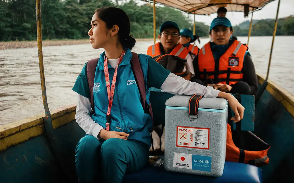 Warum impfen: Eine Gesundheitshelferin transportiert eine Kühlbox mit Impfstoffen per Boot.