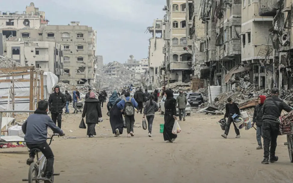 Gaza Spenden: Einwohner*innen von Gaza-Stadt sind zwischen den Trümmern der zerstörten Stadt unterwegs. 