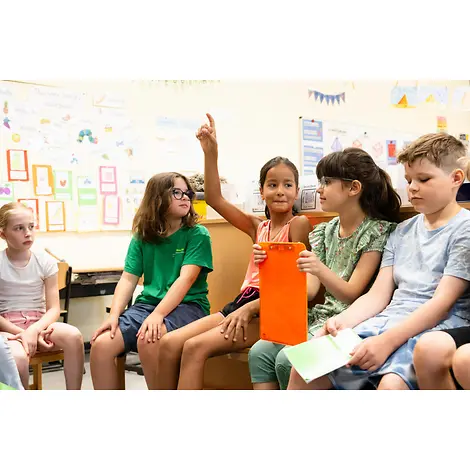 Grundgesetz einfach erklärt: Kinder sitzen in einem Klassenraum und sprechen.