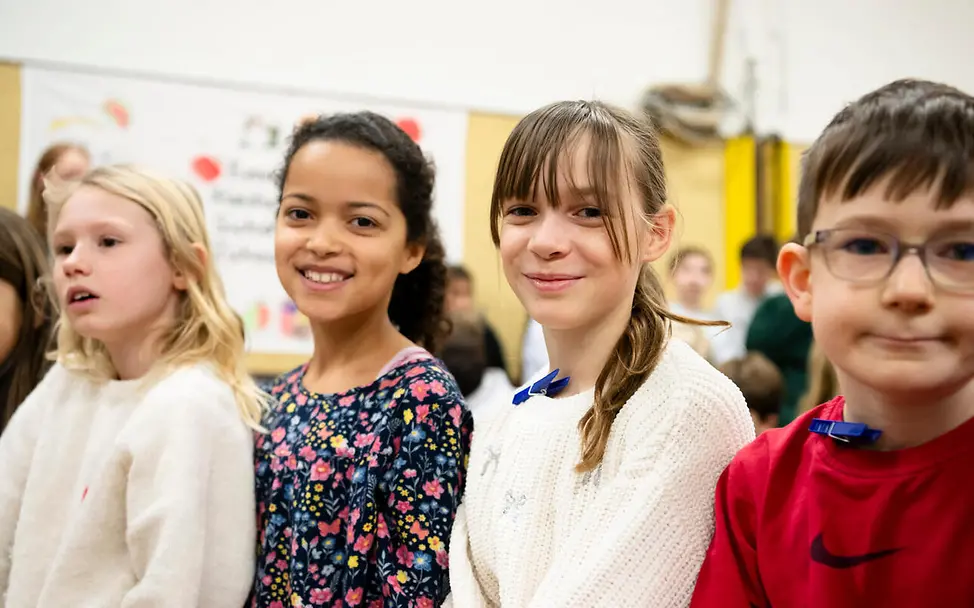 Grundgesetz einfach erklärt: Drei Kinder blicken lächelnd in die Kamera. 