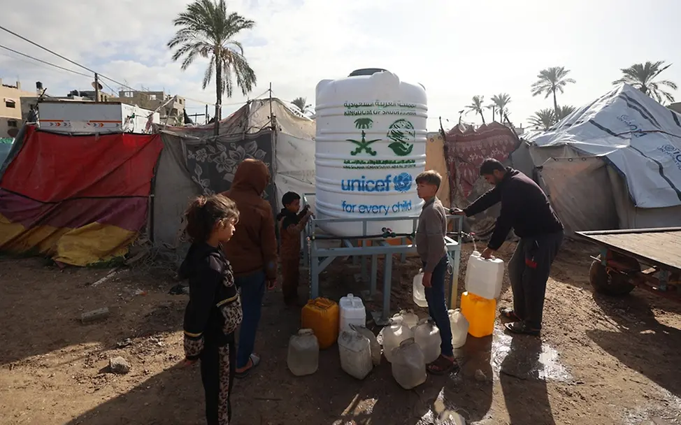 Gaza: Kinder stehen vor einem Wassertank
