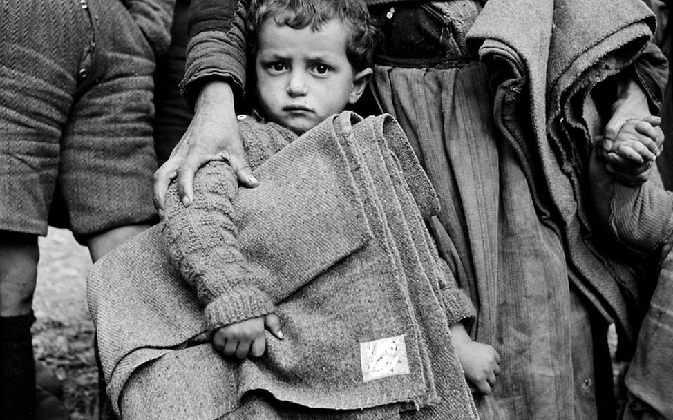 Ein Junge in Griechenland 1950 mit einer UNICEF-Decke unter dem Arm. | © UNICEF/Unknown 80 Jahre UNICEF: Nach dem Zweiten Weltkrieg half UNICEF Kindern im vom Krieg zerstörten Europa.