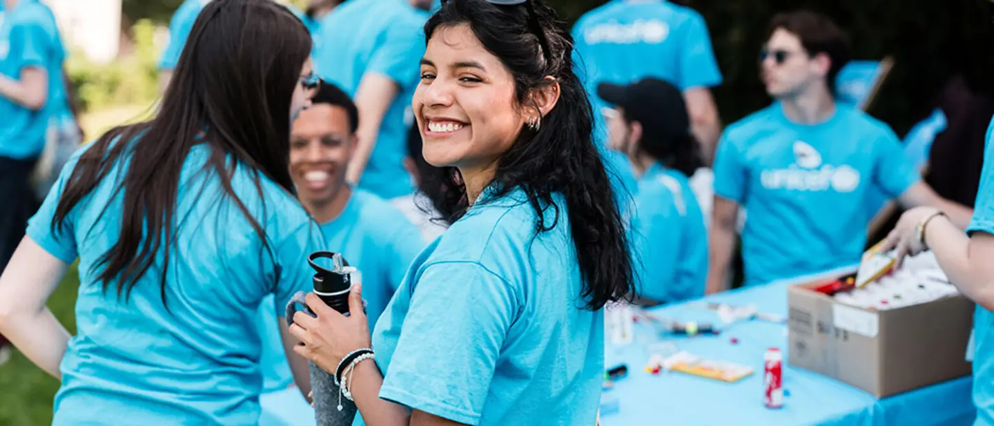 Freiwilligenarbeit junge Erwachsene: Studierende im UNICEF-Shirt kommen im Freien zusammen. 