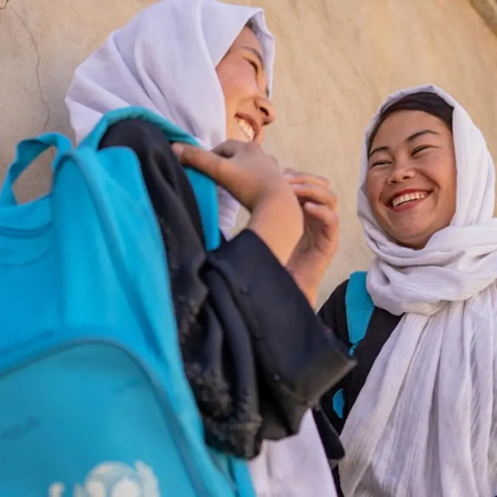 UNICEF unterstützt mit Let Us Learn die Bildung von Mädchen in Afghanistan. | © UNICEF/Naftalin Bildung in Afghanistan: Mädchen stehen lachend vor einem Lernzentrum.