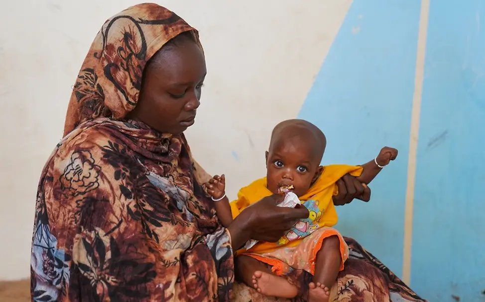 Sudan: Fatima wird von ihrer Mutter mit Erdnusspaste gefüttert