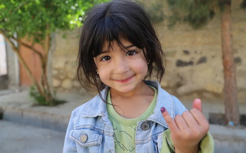 Polio Impfung: Ein Mädchen zeigt nach ihrer Schluckimpfung gegen Kinderlähmung die Markierung an ihrem Finger. 