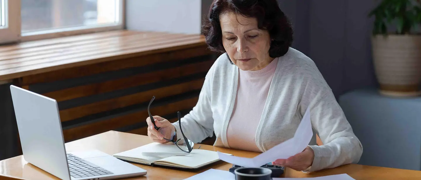 Eine Checkliste für den Todesfall bietet Angehörigen Orientierung Checkliste Todesfall: Eine Frau macht sich am Schreibtisch Notizen