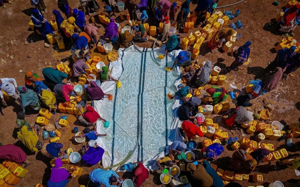Dürre: Folgen für Kinder & Ursachen: Menschen schöpfen Wasser in Somalia.