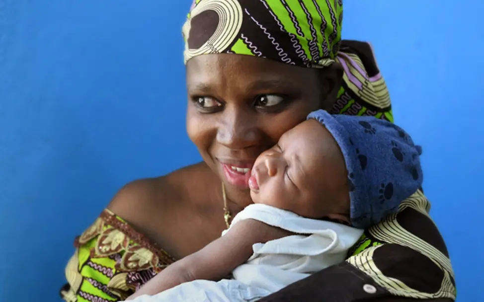 Eine Mutter hält ihr gesundes Baby im Arm, das dank des HIV-Programms von der Krankheit ihrer Mutter verschont bleibt.