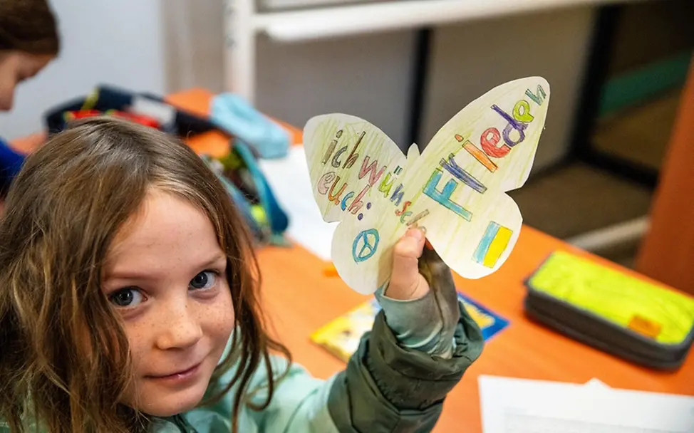 Ein Mädchen hat ihre Wünsche für die Kinder in der Ukraine auf einen Papier-Schmetterling geschrieben | © UNICEF/Zimmermann Ein Mädchen hat ihre Wünsche für die Kinder in der Ukraine auf einen Papier-Schmetterling geschrieben