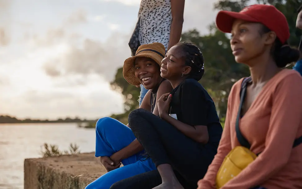 UNICEF setzt sich dafür ein, dass Mädchen und Frauen nicht mehr benachteiligt werden. | © UNICEF/Andriantsoarana SDGs einfach erklärt: Junge Frauen sitzen lachend auf einem Bootssteg