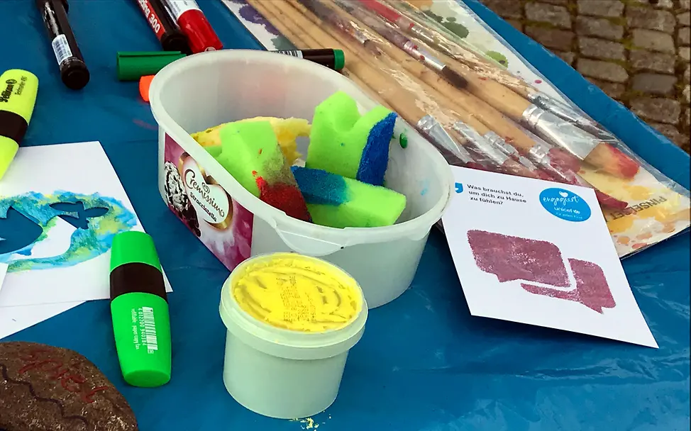 Bunte Farben und Schablonen liegen auf einem Tisch