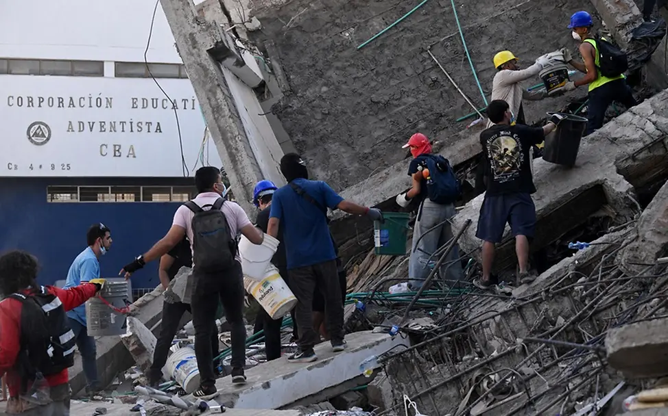 Freiwillige und Rettungskräfte suchen in Cali nach Überlebenden in den Trümmern eines eingestürzten Gebäudes. 
