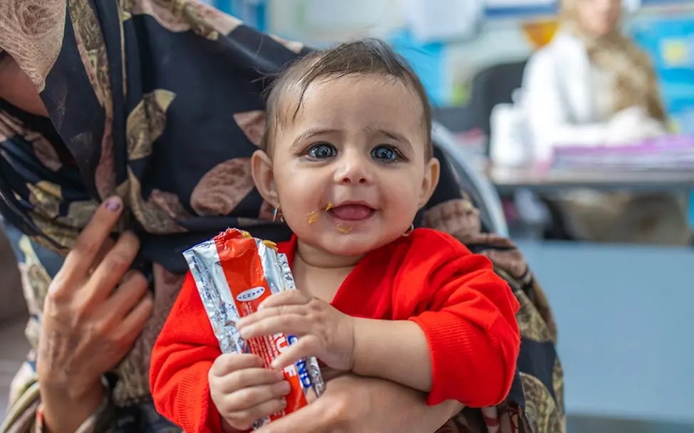 Humanitäre Hilfe: Asma hält Erdnusspaste in der Hand