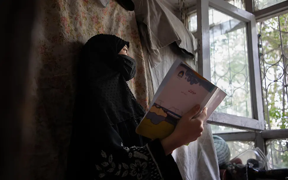 Afghanistan: Ein Mädchen liest zuhause alleine ein Buch. | © UNICEF/Azizi Afghanistan: Ein Mädchen liest zuhause alleine ein Buch.