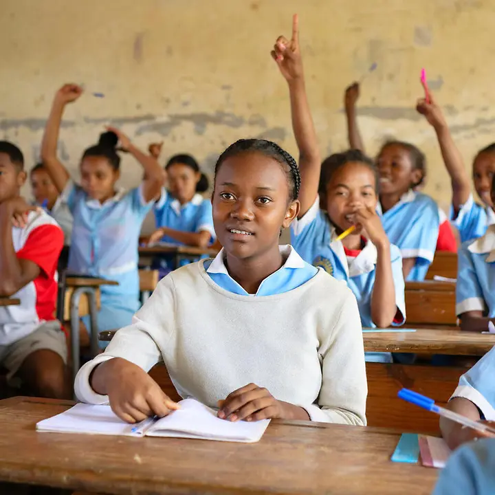 Let Us Learn: Schülerinnen und Schüler sitzen an Tischen in einem Klassenzimmer.