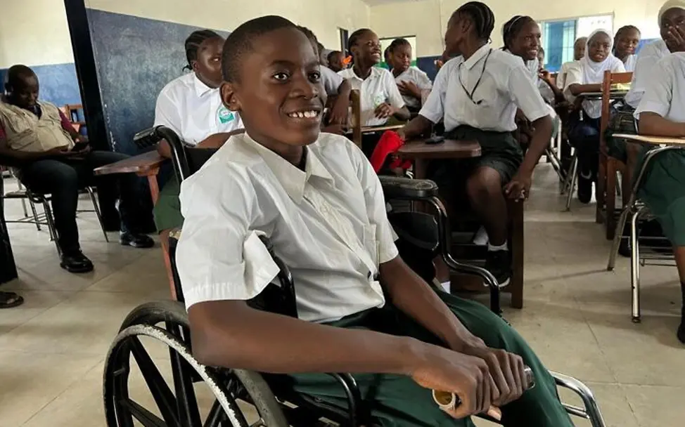 Let Us Learn UNICEF: Ein Schüler im Rollstuhl sitzt vor seiner Klasse. 