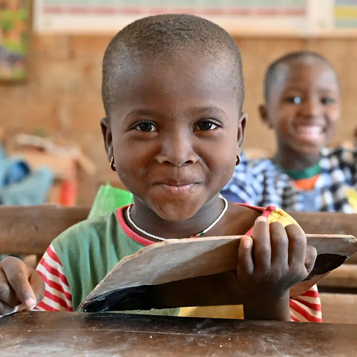 Ein Mädchen sitzt mit einer Tafel in einem Klassenzimmer in der Elfenbeinküste. | © UNICEF/Dejongh Schulen in Afrika: Unser Bildungsprogramm "Schulen für Afrika" ermöglicht auch benachteiligten Kindern Afrikas den Schulbesuch.