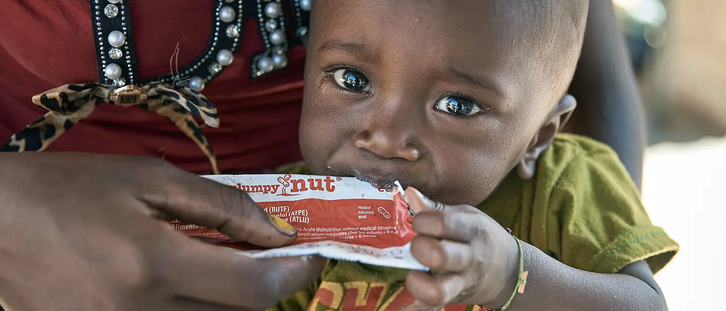 Ein Baby wird auf dem Schoß seiner Mutter mit Erdnusspaste gefüttert. | © UNICEF/Andriantsoarana Spenden für Madagaskar: Ein mangelernährtes Baby wird mit therapeutischer Erdnusspaste gegen den Hunger gefüttert.