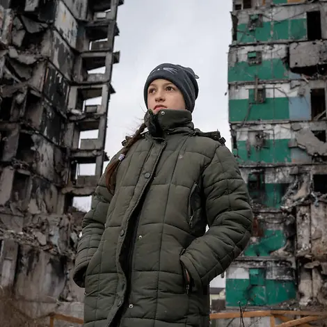 Kriege richten Zerstörung an und verursachen großes Leid bei Kindern und ihren Familien. | © UNICEF/Filippov Was ist Krieg einfach erklärt: Ein Mädchen steht vor zwei im Krieg zerstörten Häusern.
