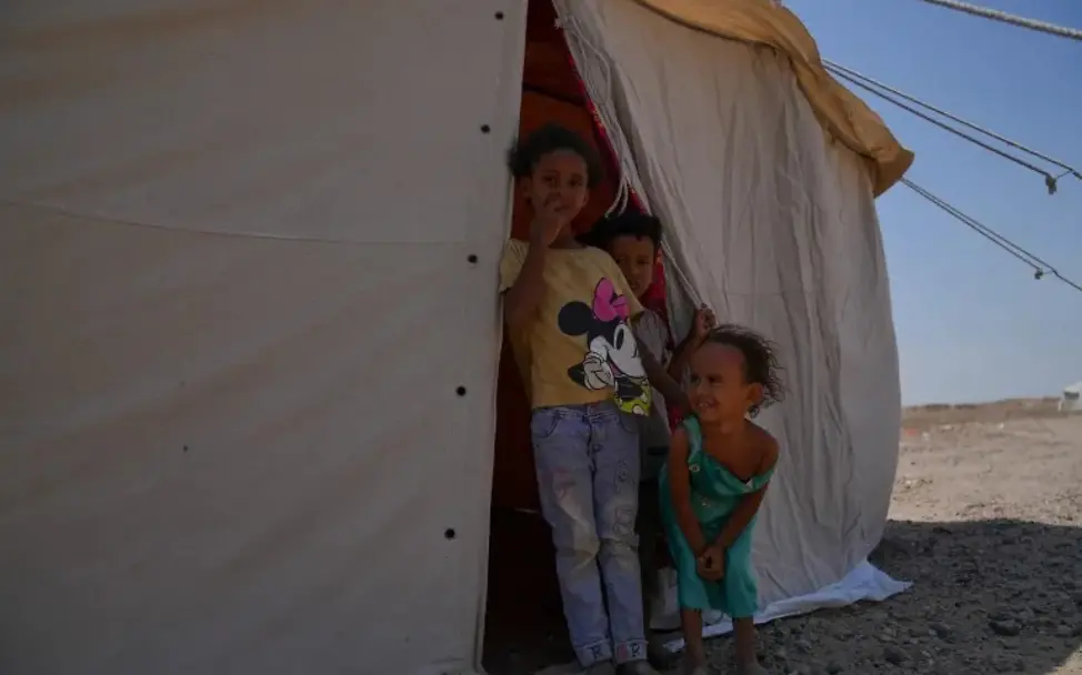 Kinder vor ihrem Zelt in einer Unterkunft für Geflüchtete im Jemen. | © UNCIEF/2026/Yem/Mahmoud Alfilastini Kinder vor ihrem Zelt in einer Unterkunft für Geflüchtete in Al-Firdos in der Nähe von Aden im Jemen.