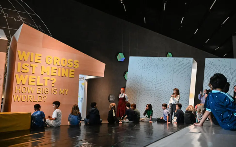 Halle des Workshops mit dem Schriftzug an der Wand "Wie groß ist meine Welt".