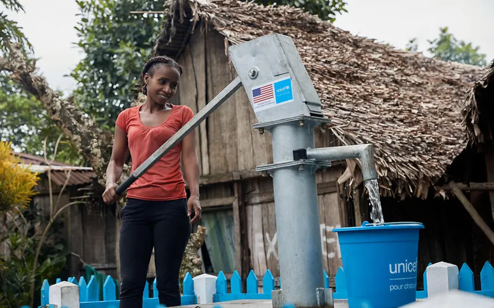 Sauberes Trinkwasser ist wichtig, damit Kinder und ihre Familien in Überschwemmungsgebieten gesund bleiben. | © UNICEF/Andriantsoarana Was ist ein Tsunami: Eine junge Frau holt Wasser an einer öffentlichen Wasserpumpe.