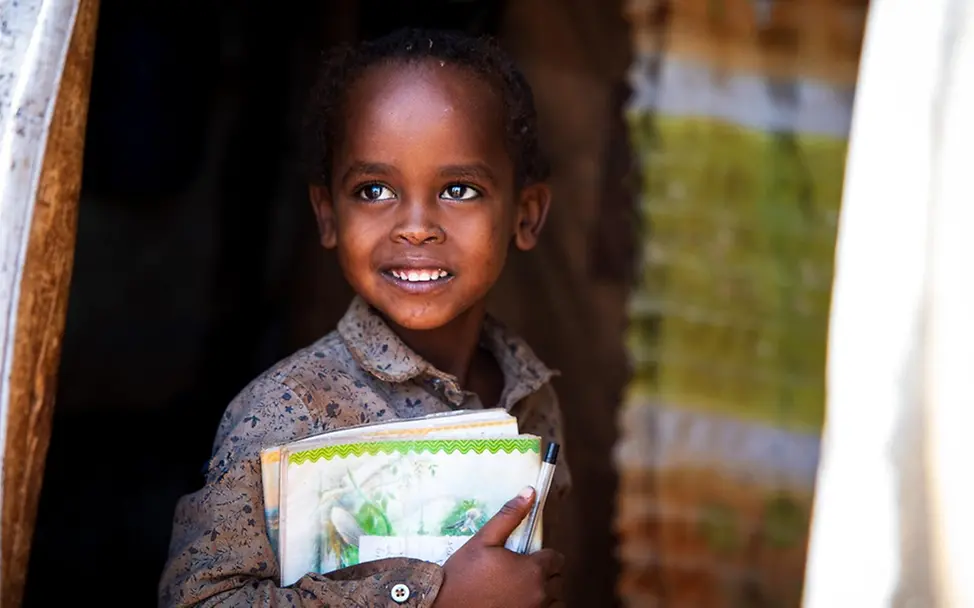 Derara hält stolz seine Schulbücher. | © UNICEF/Pouget Derara hält stolz seine Schulbücher.
