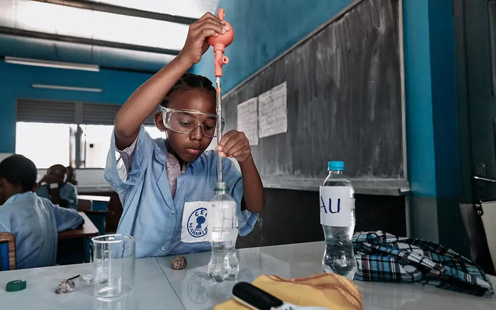 Madagaskar: Ein Mädchen führt ein chemisches Experiment in einem Klassenraum durch.