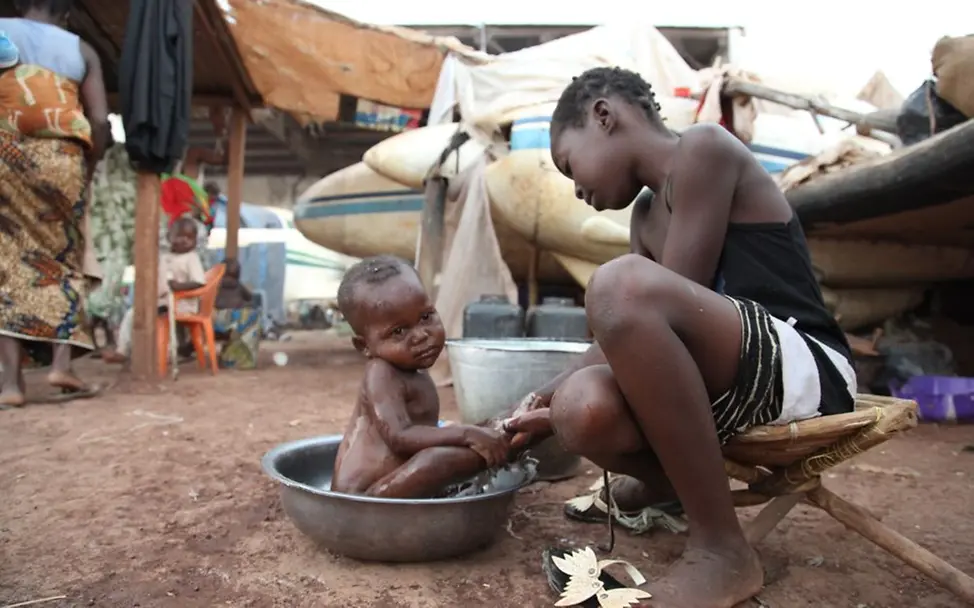 Clara wäscht ihren kleinen Bruder | © UNICEF/Roger LeMoyne Zentralafrikanische Republik: Kinder im Flugplatz-Flüchtlingslager