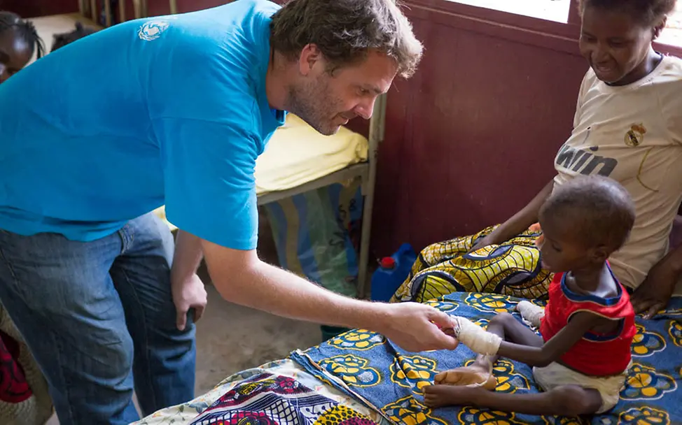 Daniel Timme zu Besuch bei einem schwer mangelernährten Kind | © UNICEF CAR Daniel Timme mit mangelernährtem Kind