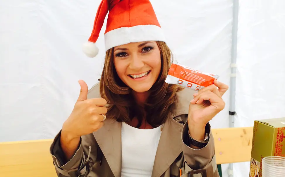 Sandra Thier mit einem Päckchen Erdnusspaste | © UNICEF DT UNICEF-Weihnachten im Sommer: Sandra Thier mit Erdnusspaste