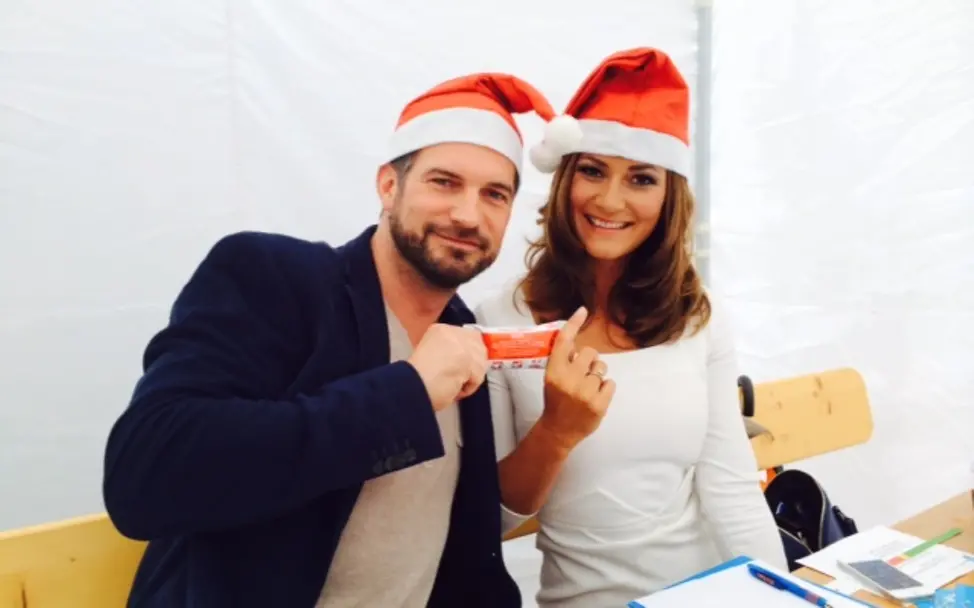 Sandra Thier mit Simon Böer und der Erdnusspaste | © UNICEF DT UNICEF-Weihnachten im Sommer: Schauspieler Simon-Böer