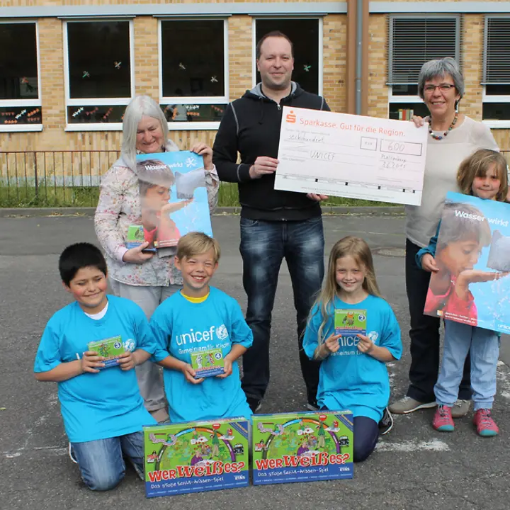 Die drei eifrigsten Läufer von links im Unicef T-Shirt Anastasis Mitros, Leon Busch und Carina Göbel bei der Spendenübergabe mit Schulleiter Nico Schröder UNICEF Plettenberger Woche©UNICEF/Gundel Blanke