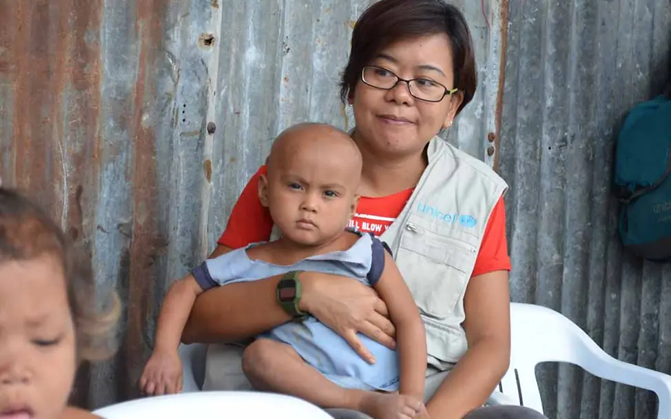 Kinderschutzleiterin Faye mit einem der Babys | © UNICEF/Mäusbacher Philippinen Kinderschutz