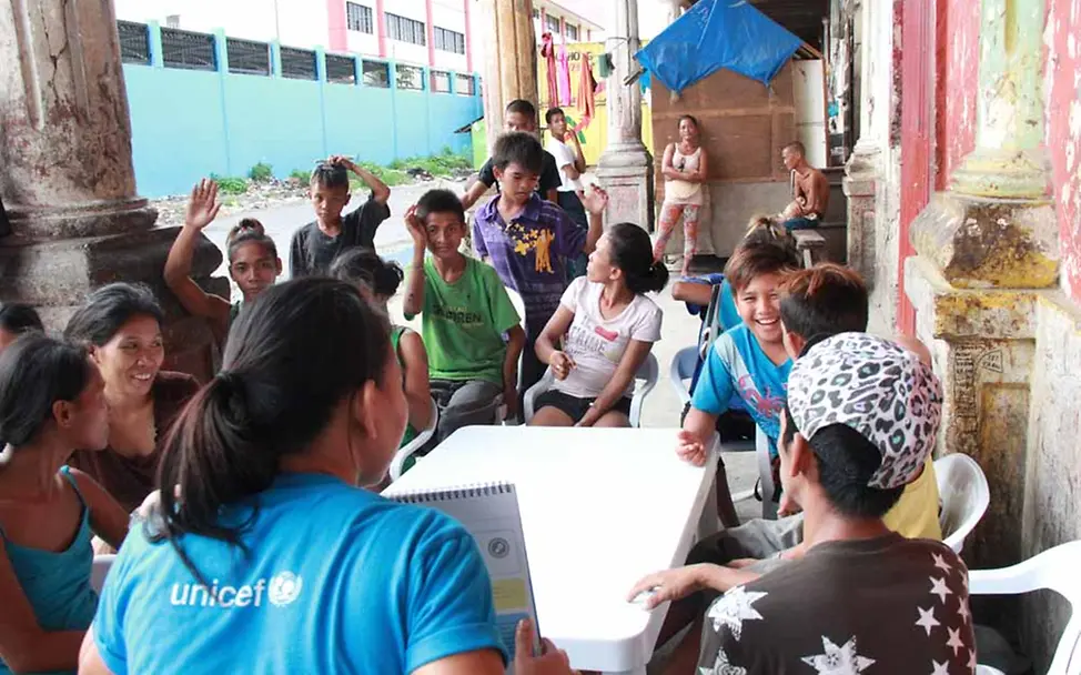 Vorlesen, Buchstaben üben, zusammen lachen | © UNICEF/Mäusbacher Philippinen Kinderschutz
