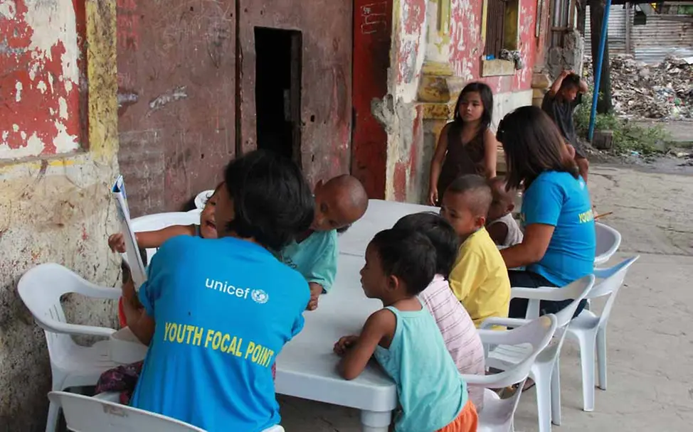 Sozialarbeiterin Amy (links) liest immer vor und übt mit den Kindern die Buchstaben | © UNICEF/Mäusbacher Philippinen Kinderschutz