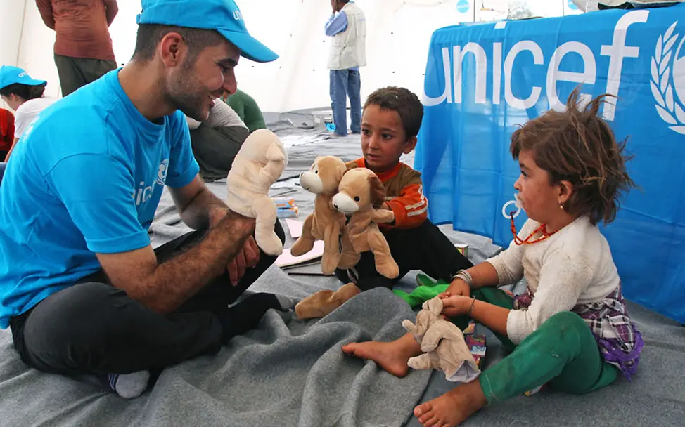 Ein UNICEF-Helfer betreut Flüchtlingskinder | © UNICEF/Khuzaie Irak: UNICEF-Hilfe für traumatisierte Kinder