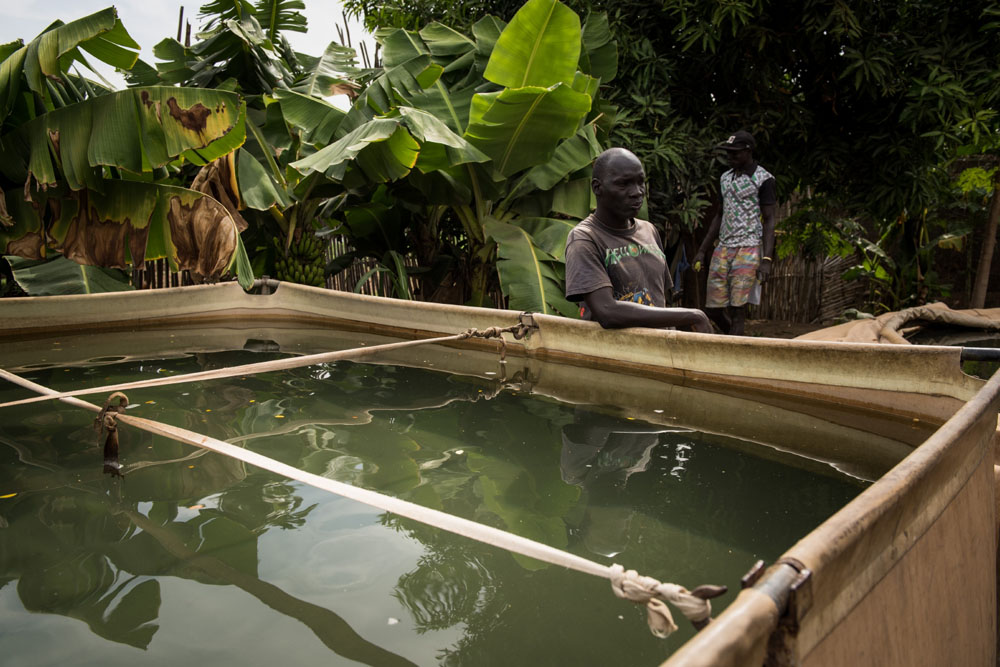 Südsudan: Louis steht neben einem Wasserspeicher mit Wasser aus dem weißen Nil