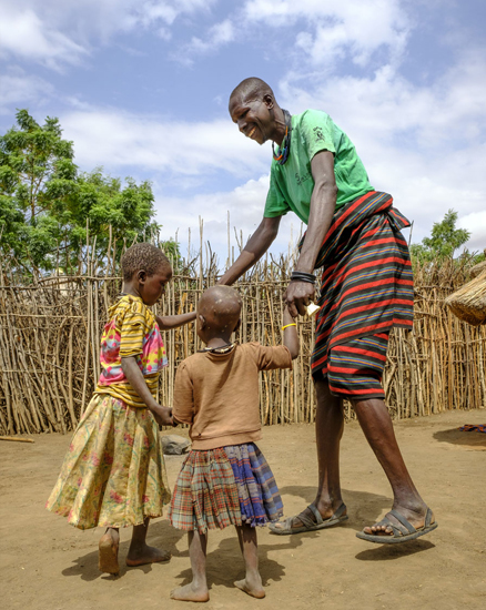Loli tanzt mit seiner Tochter Nayo und seinem Sohn Akol | © UNICEF/Ose Uganda: Ein Vater tanzt mit seinen beiden Kindern im Freien