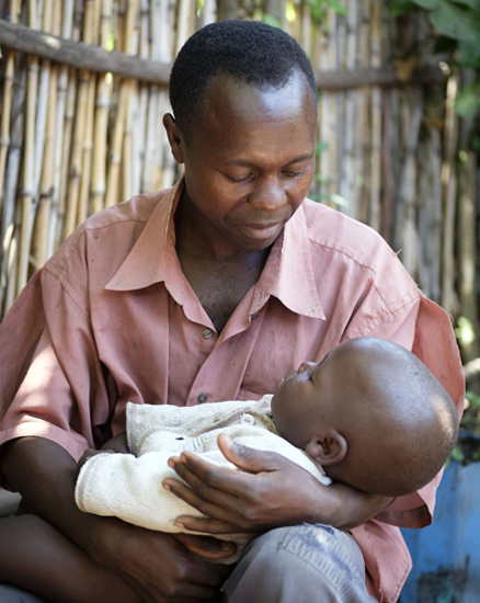 Uganda: Ein Vater hält seinen zwei-jährigen Sohn auf dem Arm