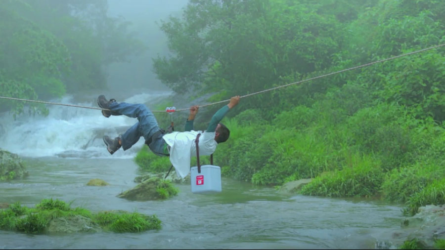 In Indien klettert ein Mann mit Impfstoffen über einen Fluss | © UNICEF/Lucky8 LLC Indien: Ein Träger klettert an einem Seil über einen Fluss