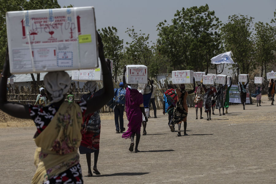 Lebensrettende Impfstoffe werden von den Frauen im Südsudan transportiert | © UNICEF/Modola Südsudan: Frauen transportieren Kisten mit Impfstoffen durch die Straßen