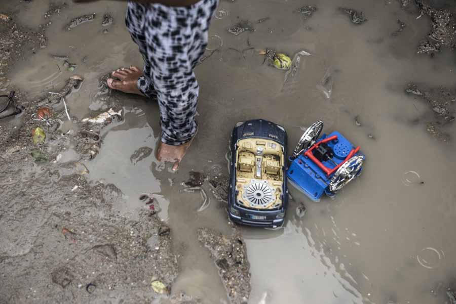 Cambodia: Ein Junge steht barfuß in einer Schlammpfütze vor seinem Zuhause.