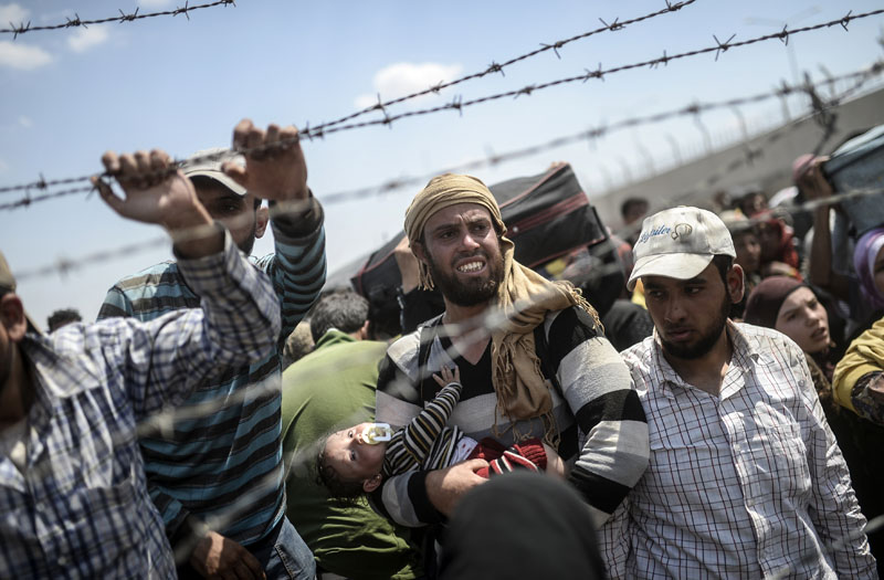 Grenze Syrien/Türkei: Flucht durch den Stacheldraht | © Bülent Kiliç/AFP Grenze Syrien/Türkei: Flucht durch den Stacheldraht | © Bülent Kiliç/AFP