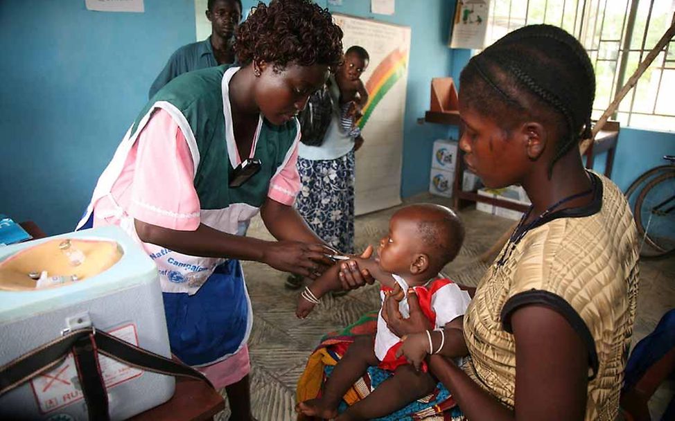 Sierra Leone: Gesundheitshelferin impft Kind in einer Gesundheitsstation