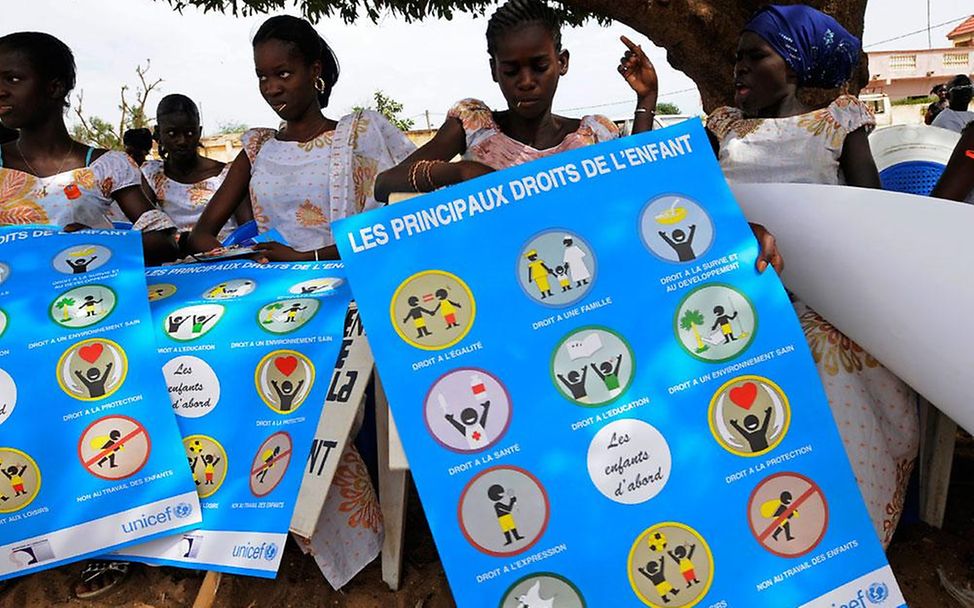 Beschneidung in Senegal: Mädchen präsentieren Poster über Kinderrechte